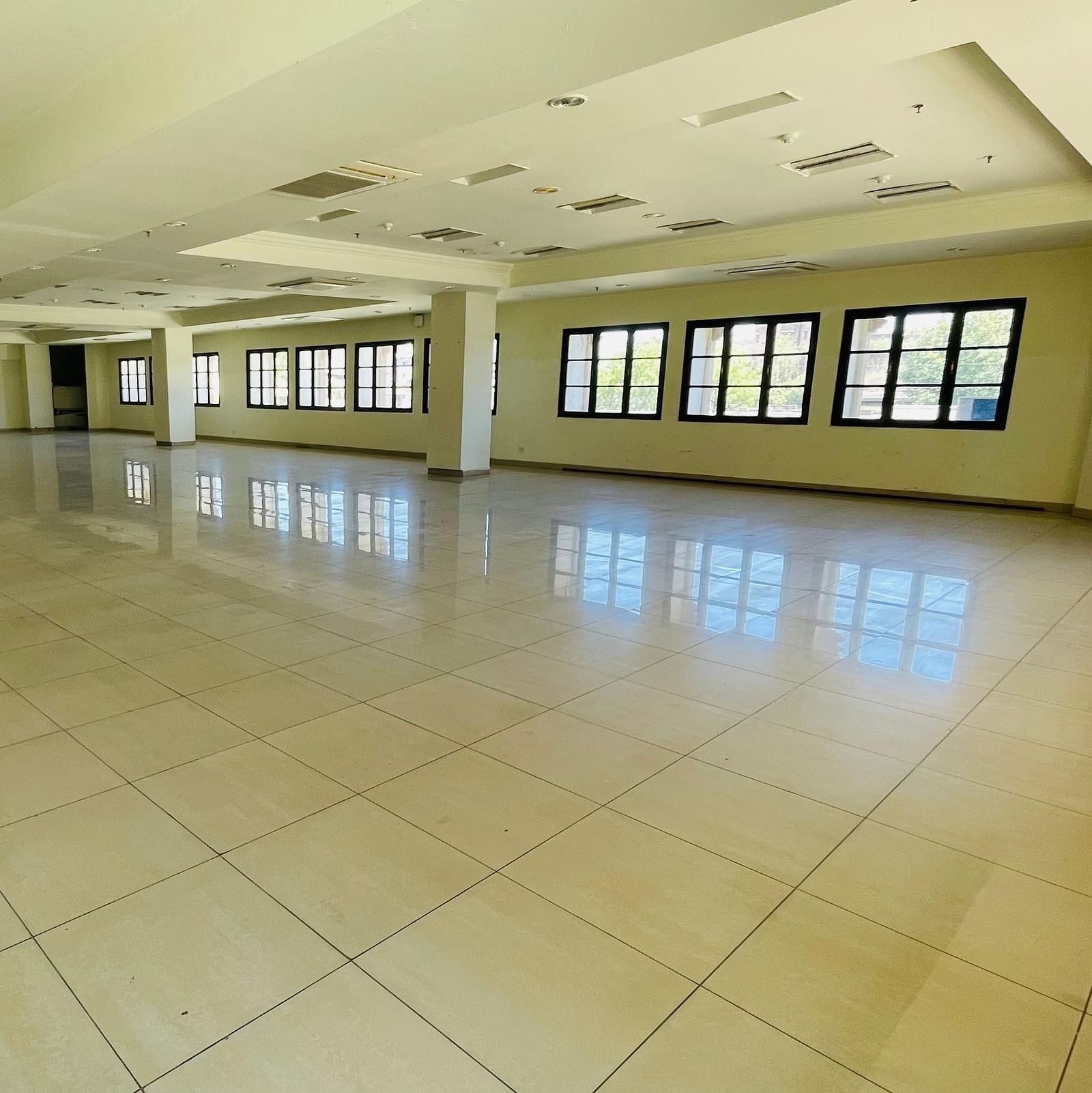 An empty interior view of Raj Darbar Hall with pillars and multiple windows.