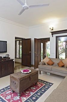 An image of a room with sofa set, table, flat screen TV, rug, and minimal decoration - MANVAR Resort & Desert Camp