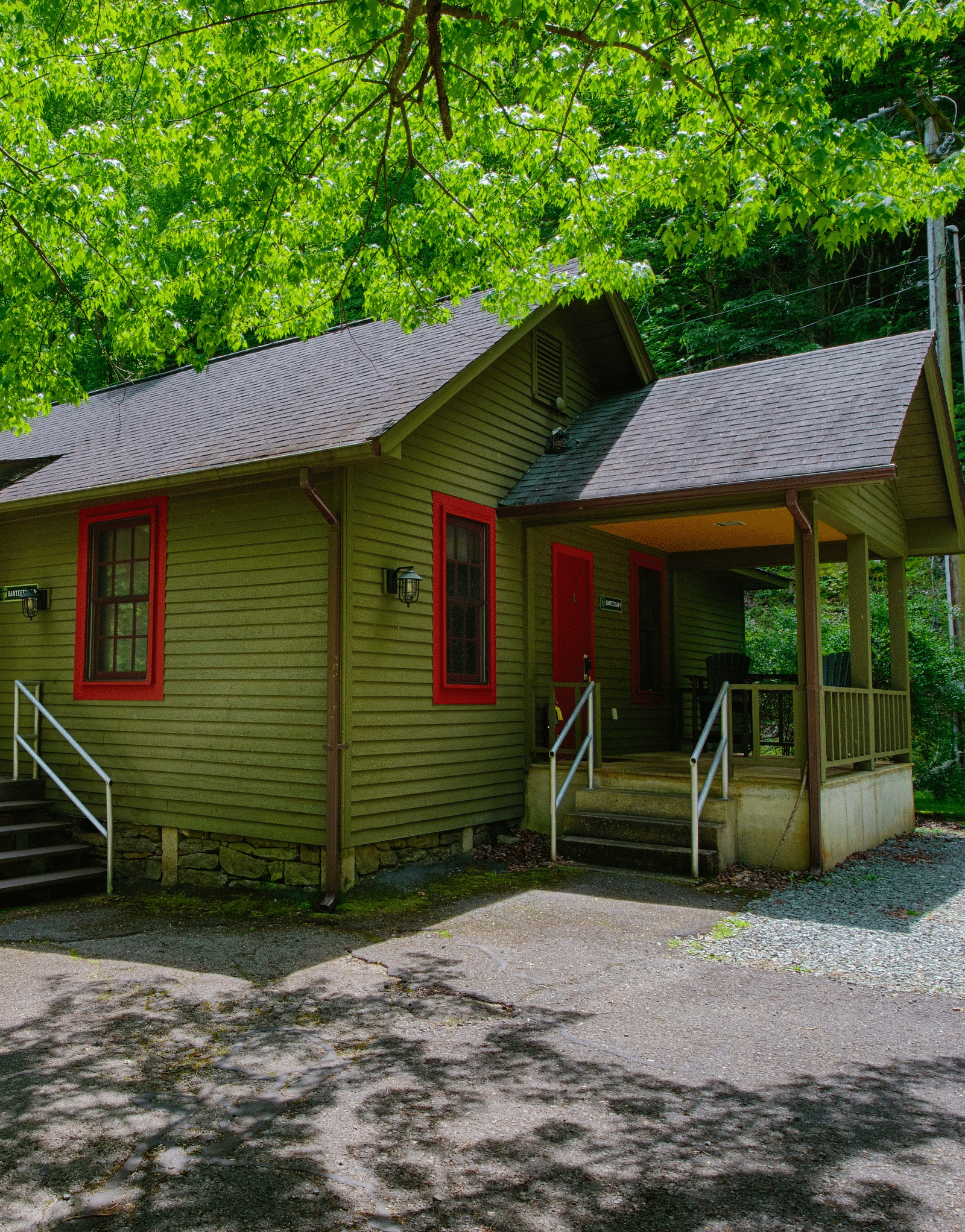 facade image of a cabin with green exterior walls camouflaging with the lush green surroundings - Historic Tapoco Lodge