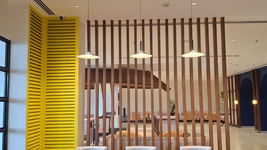 View of a seating area behind a wooden partition at Cloud9 Sarovar Premiere, Goa, offering a cosy and private spot for relaxation