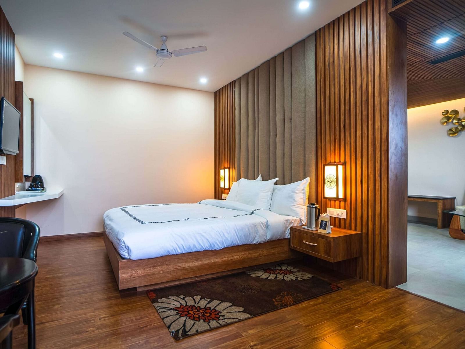 A comfortable bedroom at Mansha Palace opens into a separate living area with a sofa and wall art.