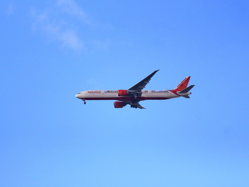 Commercial passenger aircraft flying through a clear blue sky during a daytime journey.