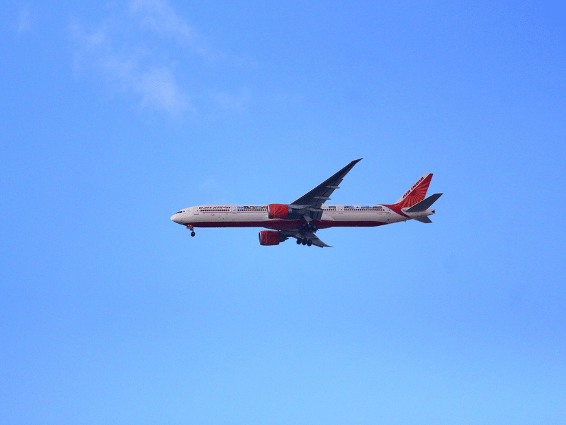 Commercial passenger aircraft flying through a clear blue sky during a daytime journey.