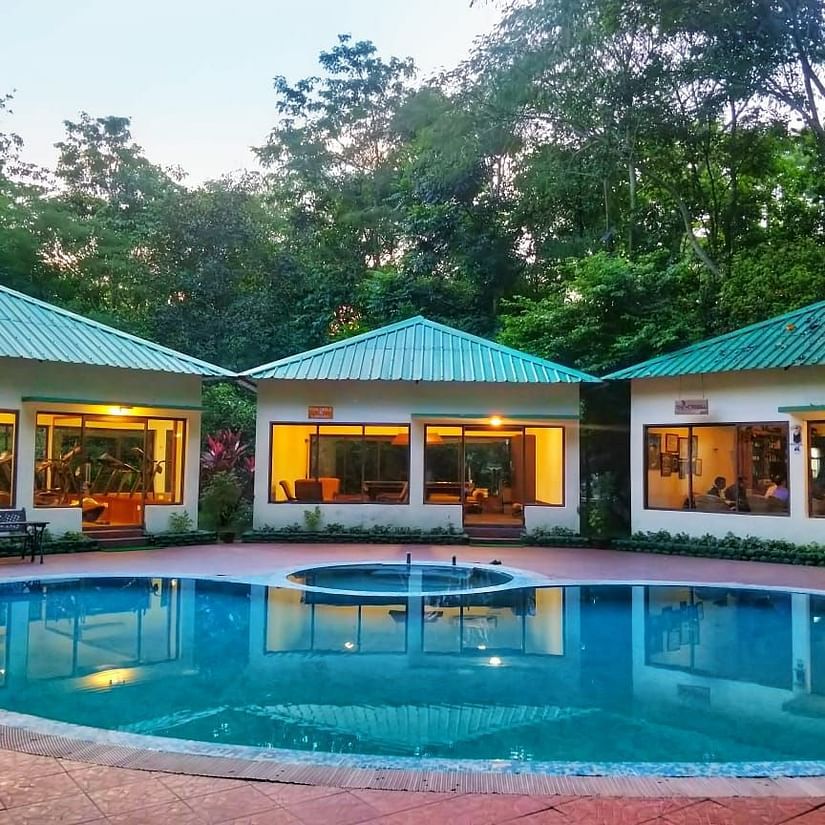 a shot of the exterior of The Riverwood Forest Retreat, Dooars with a swimming pool in front of it