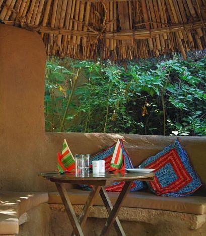 A close up shot of the seating arrangement of the Taasli Restaurant at Manvar Shergarh with a table laid out with crockery - Manvar Resort & Desert Camp