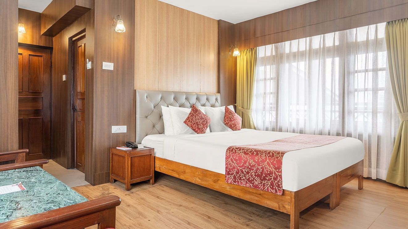 Image of a room with bed and large windows at Summit Tashi Ghang Heritage Resort, Pelling