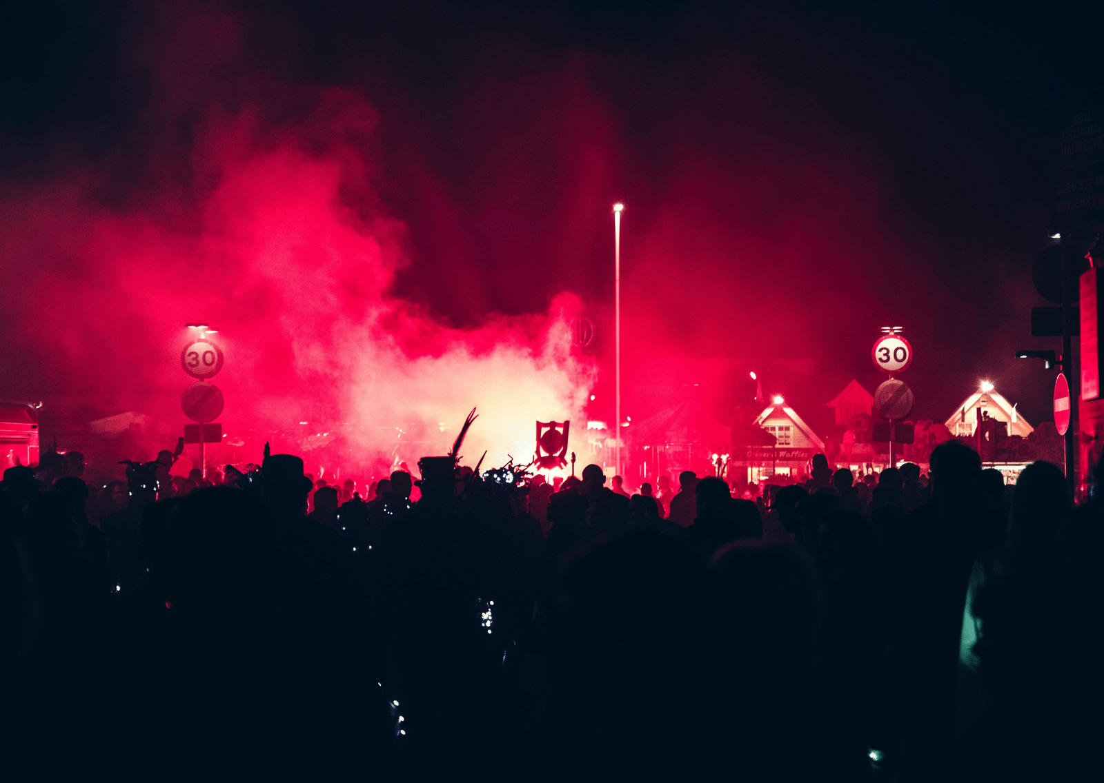 A live performance with red lighting and smoke effects on stage