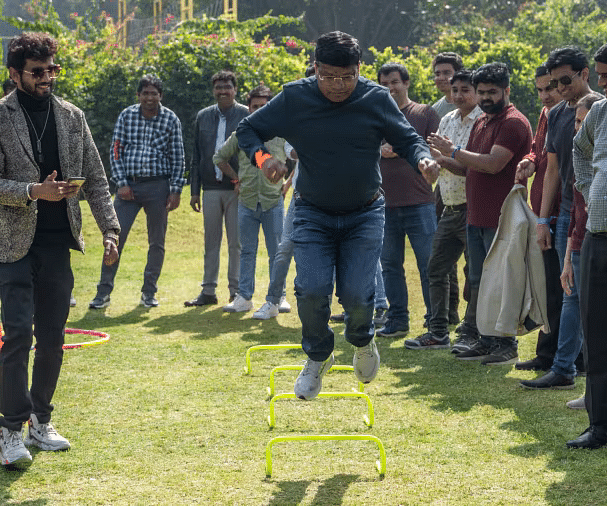 Group of people participating in a team-building activity on the lawn at Karma Chalets.