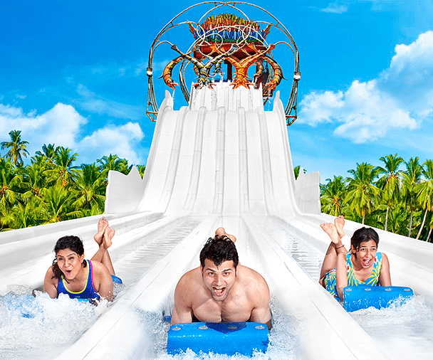 three people going down a slide at Water Kingdom