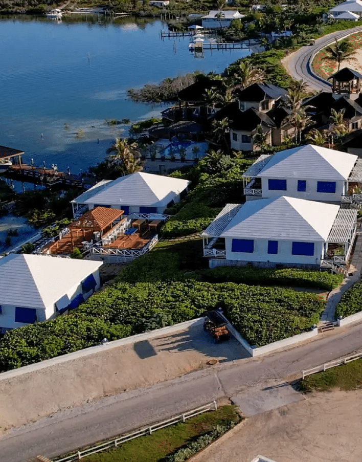 Aerial view of coastal houses near the beach, including green lawns and palm-lined pathways | Abaco Inn