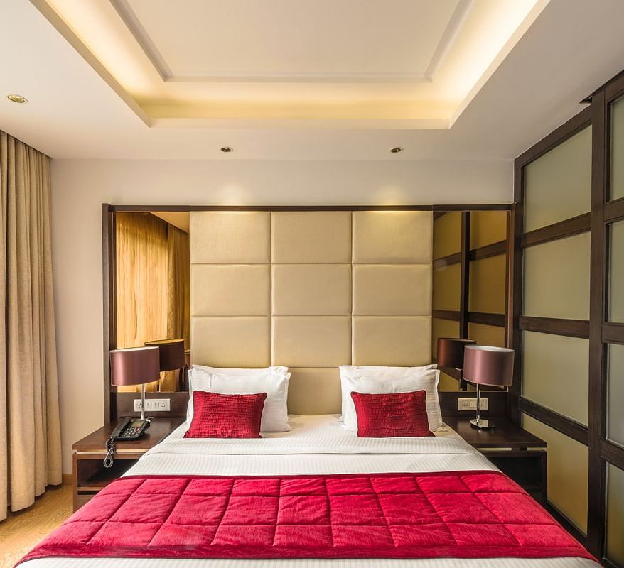 A Hotel bedroom with large bed, red bedspread and padded headboard - TGI Grand Fortuna, Hosur