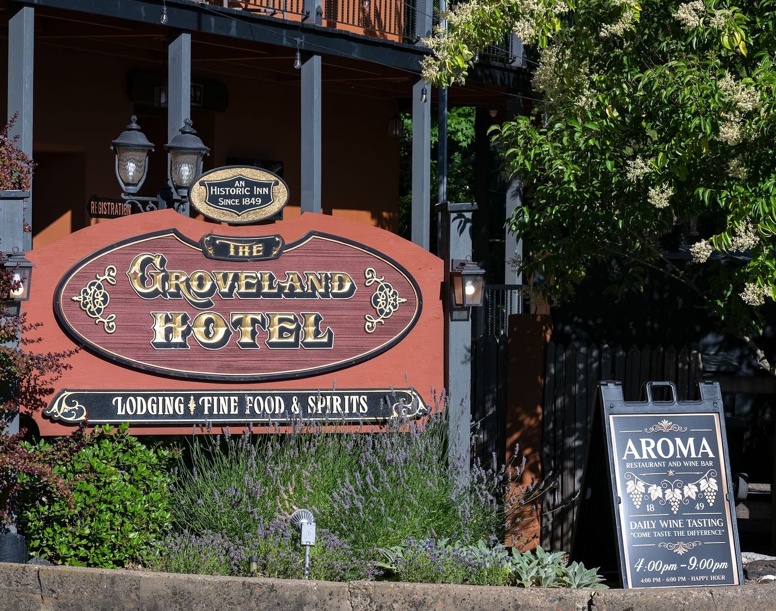 Exterior view of the entrance sign and garden at The Groveland Hotel.