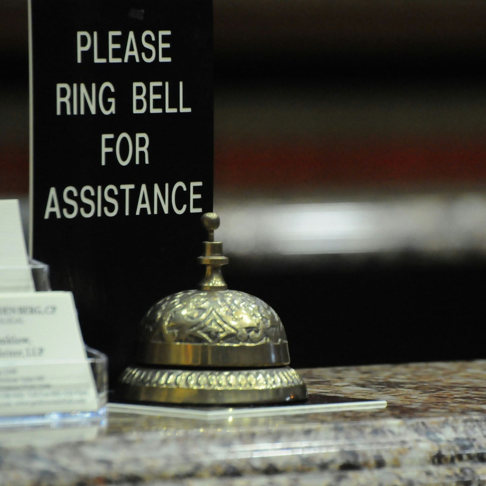 Hotel reception bell with Please ring bell for assistance signage