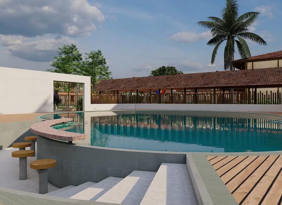 A resort with a pool area, including steps leading into the water and surrounding buildings, under a partly cloudy sky.| Ayana Resorts & Convention, Hyderabad