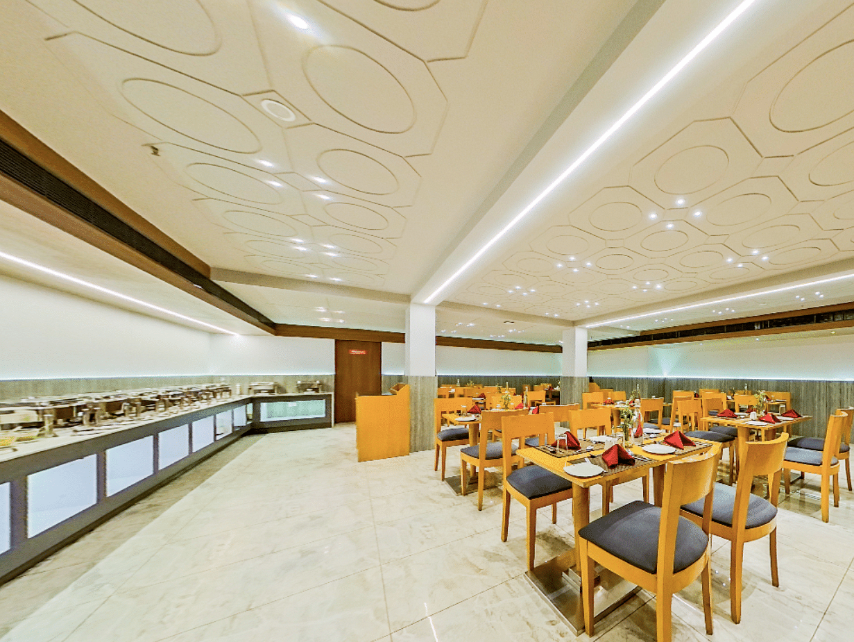 Spacious dining hall featuring buffet counter and multiple seating areas at Lords Eco Inn Dahej, with elegant marble columns and decor