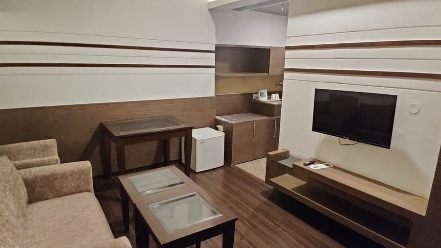 A room with a sofa, table, and decorative wall panels, showing a cosy and modern interior - VITS Gurugram