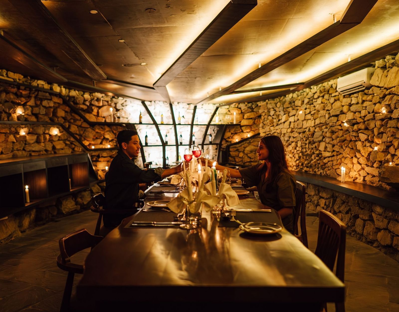 A side view of two people sitting at a long rectangular table in a well-lit dining space | Kavya Resort & Spa, Nagarkot