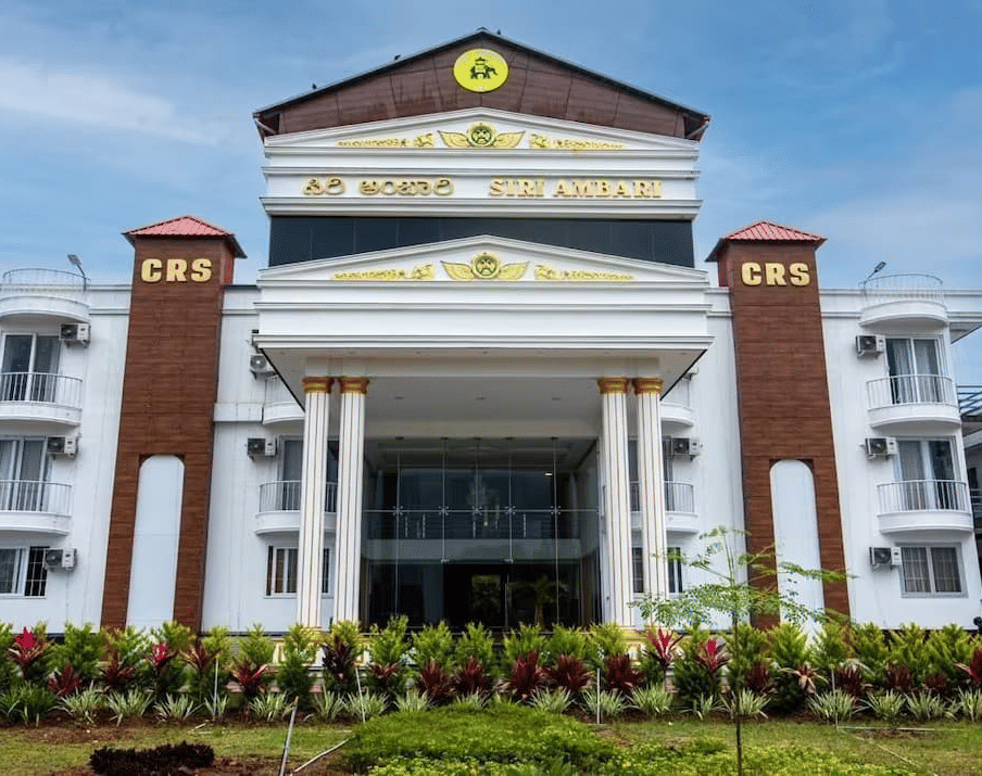 Grand exterior view of Siri Ambari Resorts and Spa, featuring a majestic white building with landscaped gardens in front.