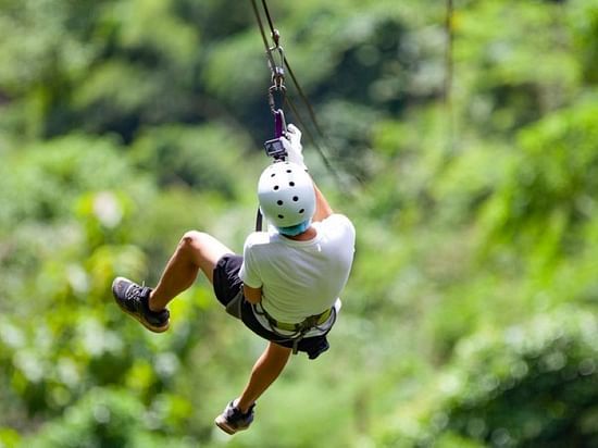 A person joyfully experiencing the Flying-fox activity at our resort in Gokarna - Stone Wood Nature Resort, Gokarna