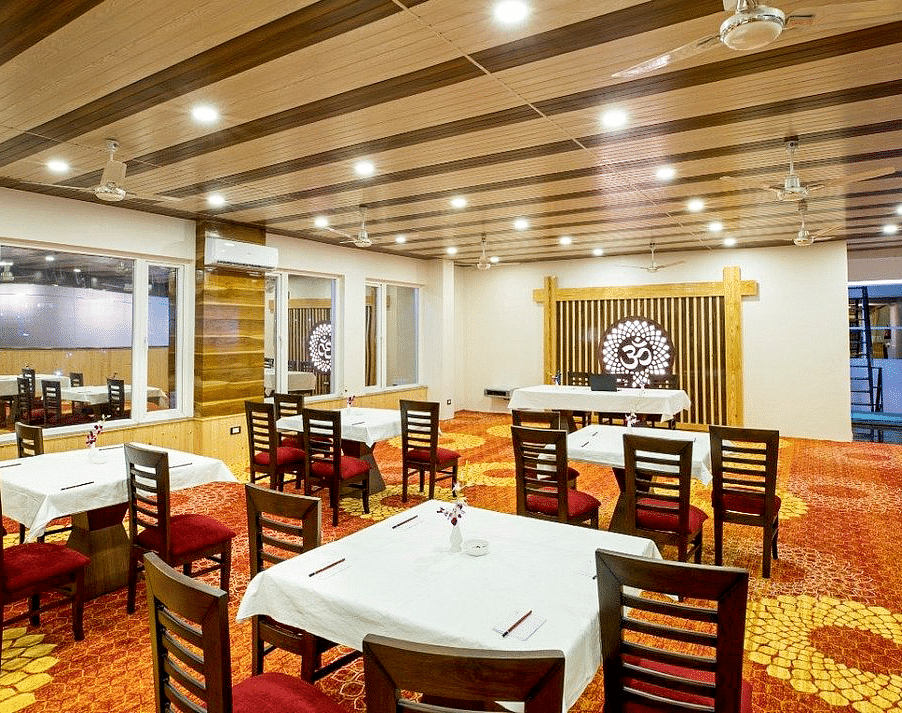 Full view shot of the Banquet Hall taken from behind featuring an Om symbol at the far end of the hall at Regenta Inn DLS.
