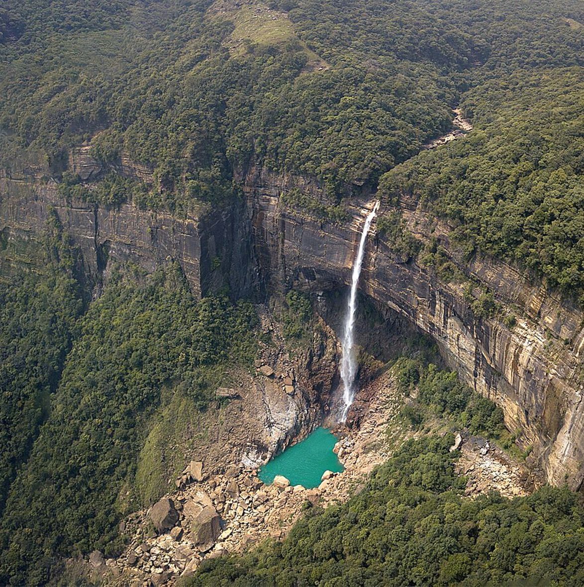A view of a single waterfall with a small water body at its base near Polo Resort Cherrapunjee.