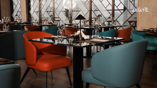 Asiatic Rooftop Bar and Restaurant interiors featuring tables, chairs, with glasses on top of the tables.