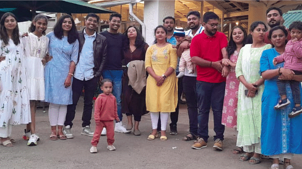 Group photo of families and children standing together, smiling outside a building.