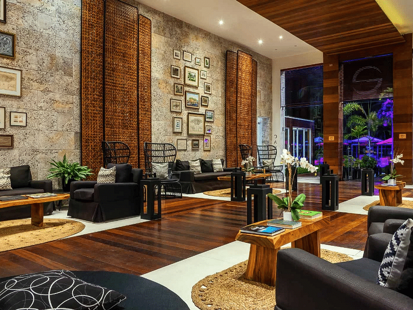 A warmly lit hotel lobby in Jamaica with teapoys and couchec - S Hotel Montego Bay, Jamaica