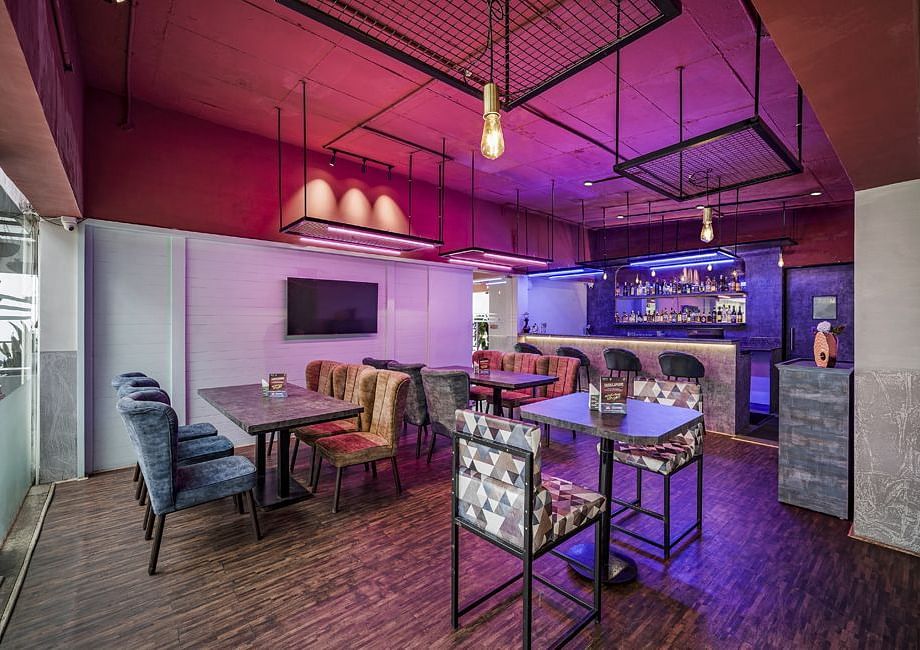 An image of the Bryants Lounge with seating arrangement, and decorative lighting hanging from the ceiling - GReaT Trails Kodaikanal By GRT Hotels
