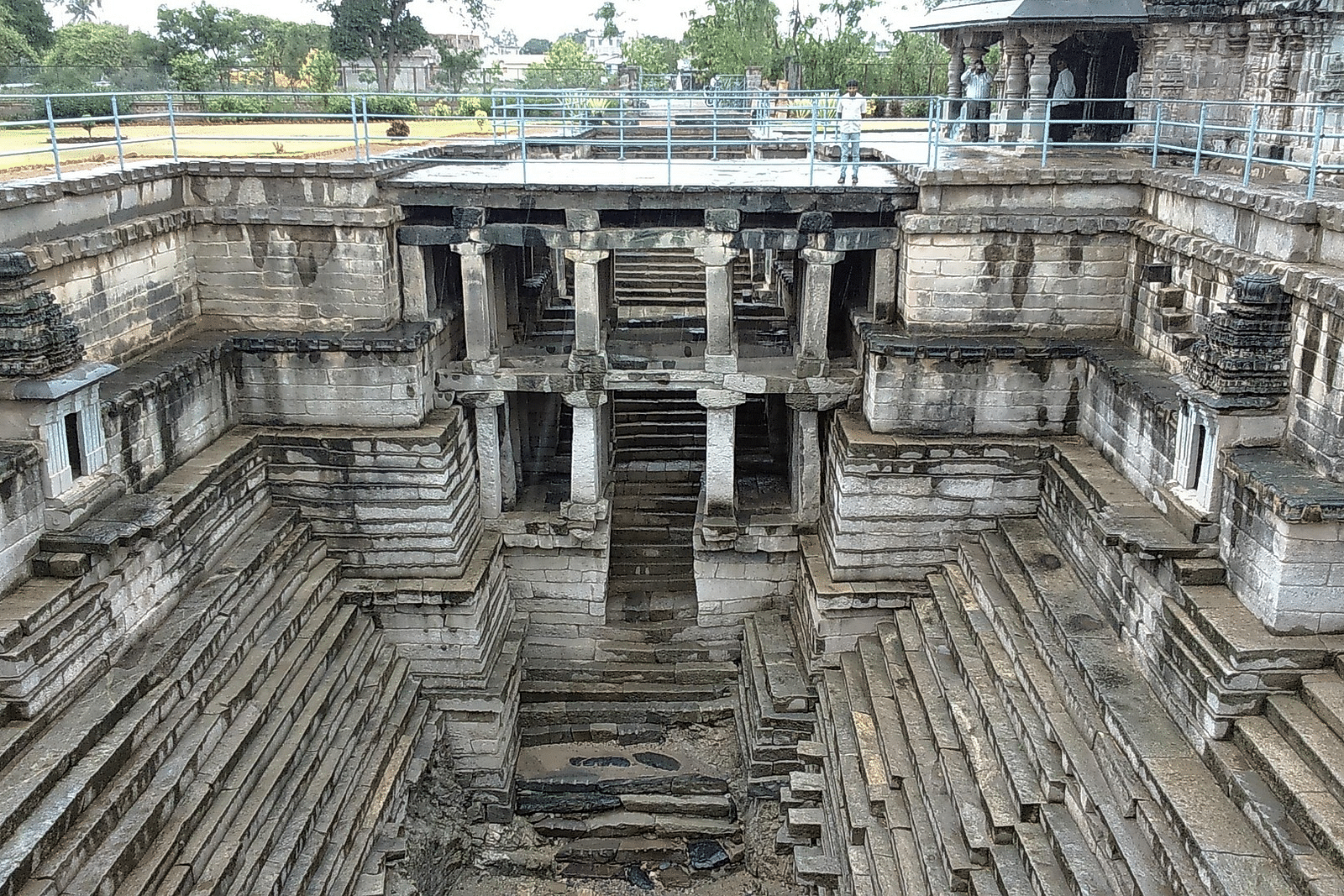 An overview of an ancient stepwell with steps leading down to the water below.