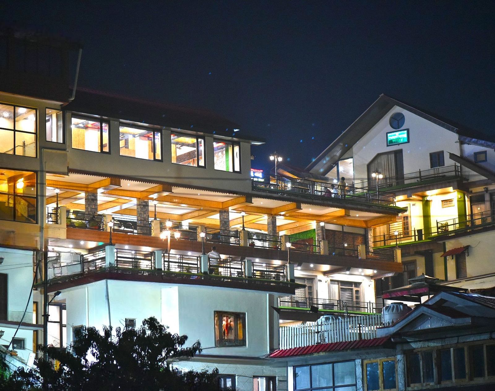 Facade image with warm lighting of DLS Dalhousie Valley Resort taken at night.