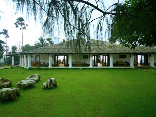 green lawn with a bungalow in the background at Parisons Plantation - one of the best Farm Houses in Wayanad