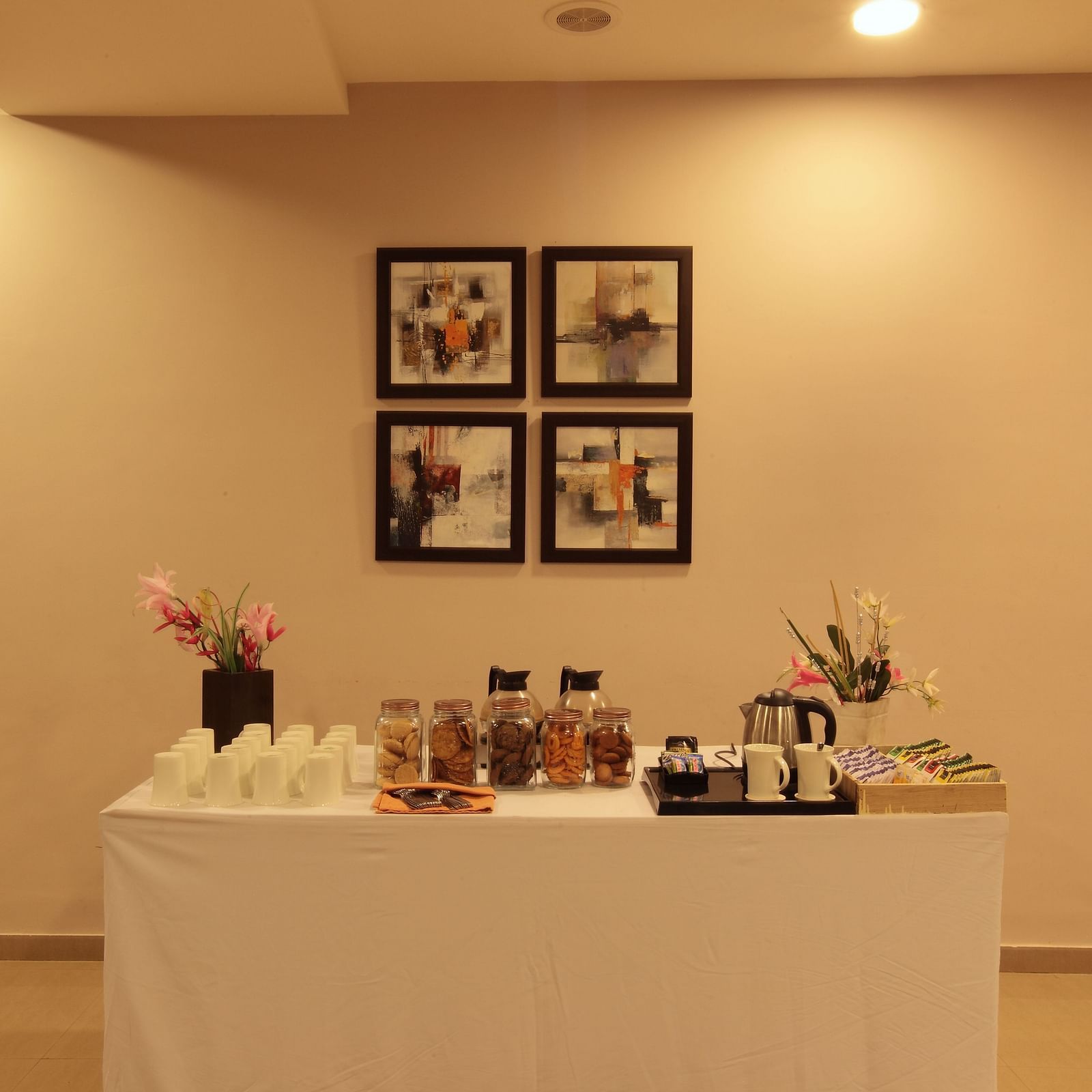 A table with snacks and tea and coffee maker at Starlit Suites, Bangalore