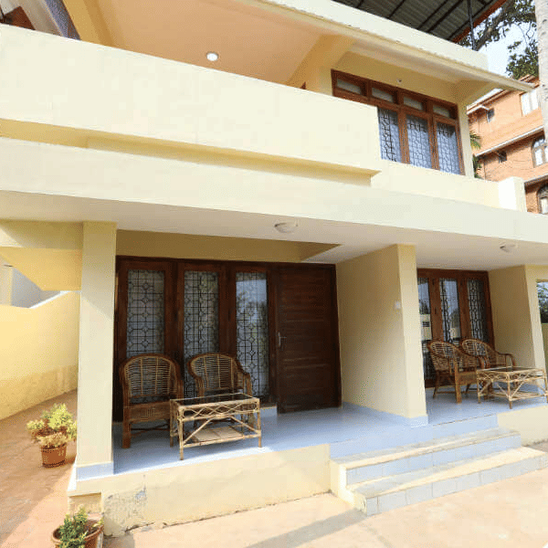 A building entrance of Abad Serviced with steps, seating, and an open porch area