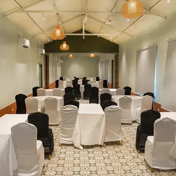 A conference hall set up with chairs around tables at Indie Stays Resort, Goa.