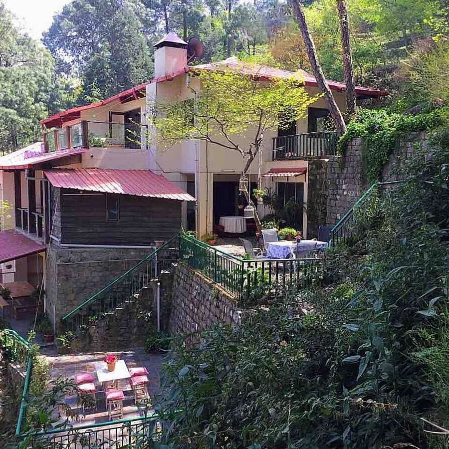 Facade view of SOUTHGATE KASAULI BY ZENQ with bush covering them at the front. 