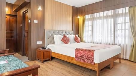 Image of a room with bed and large windows at Summit Tashi Ghang Heritage Resort, Pelling