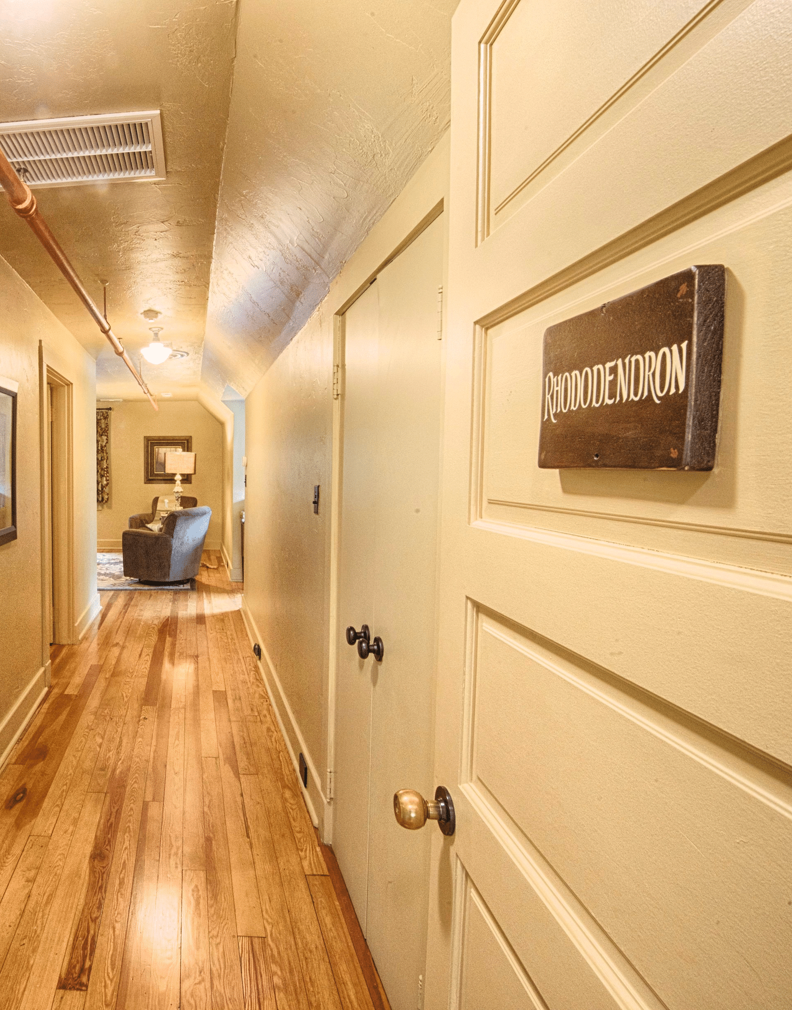 the corridor with wooden flooring and white colored doors leading to various rhododendron suites - Historic Tapoco Lodge