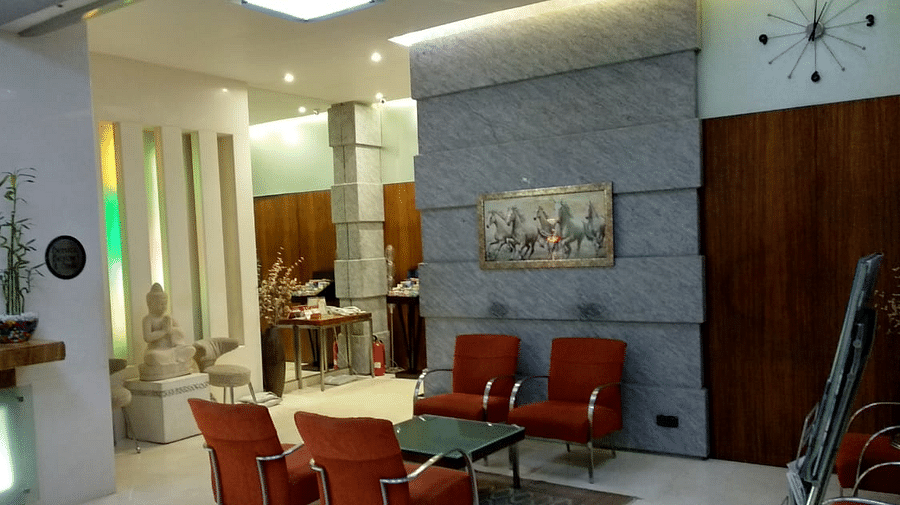 Reception area with a comfortable chairs around a glass table at Regency Hotel, Mumbai.