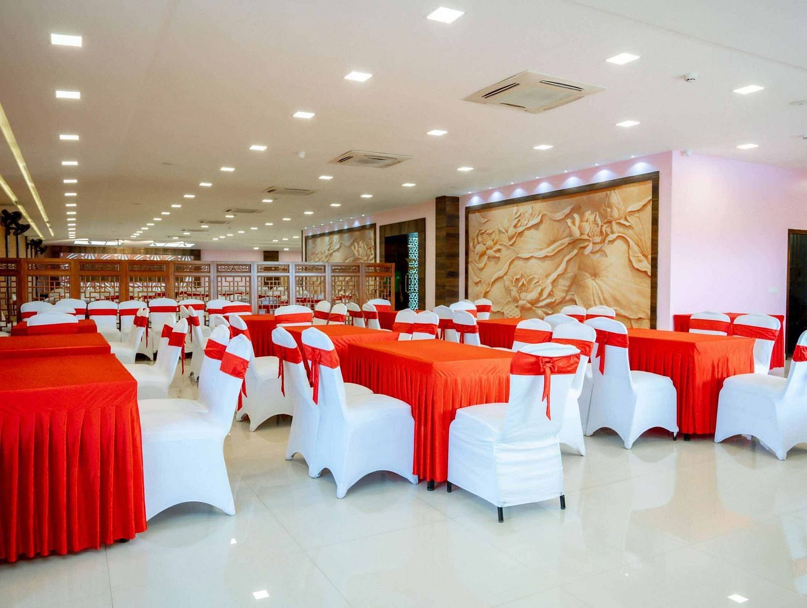A banquet hall at Mansha Hotel Regency set up for an event, featuring round tables and white chairs.