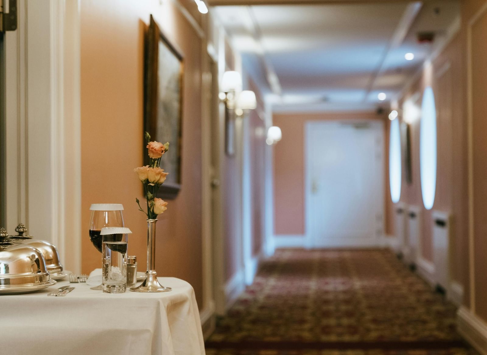 A trolley with dishes placed on it, in a corridor.