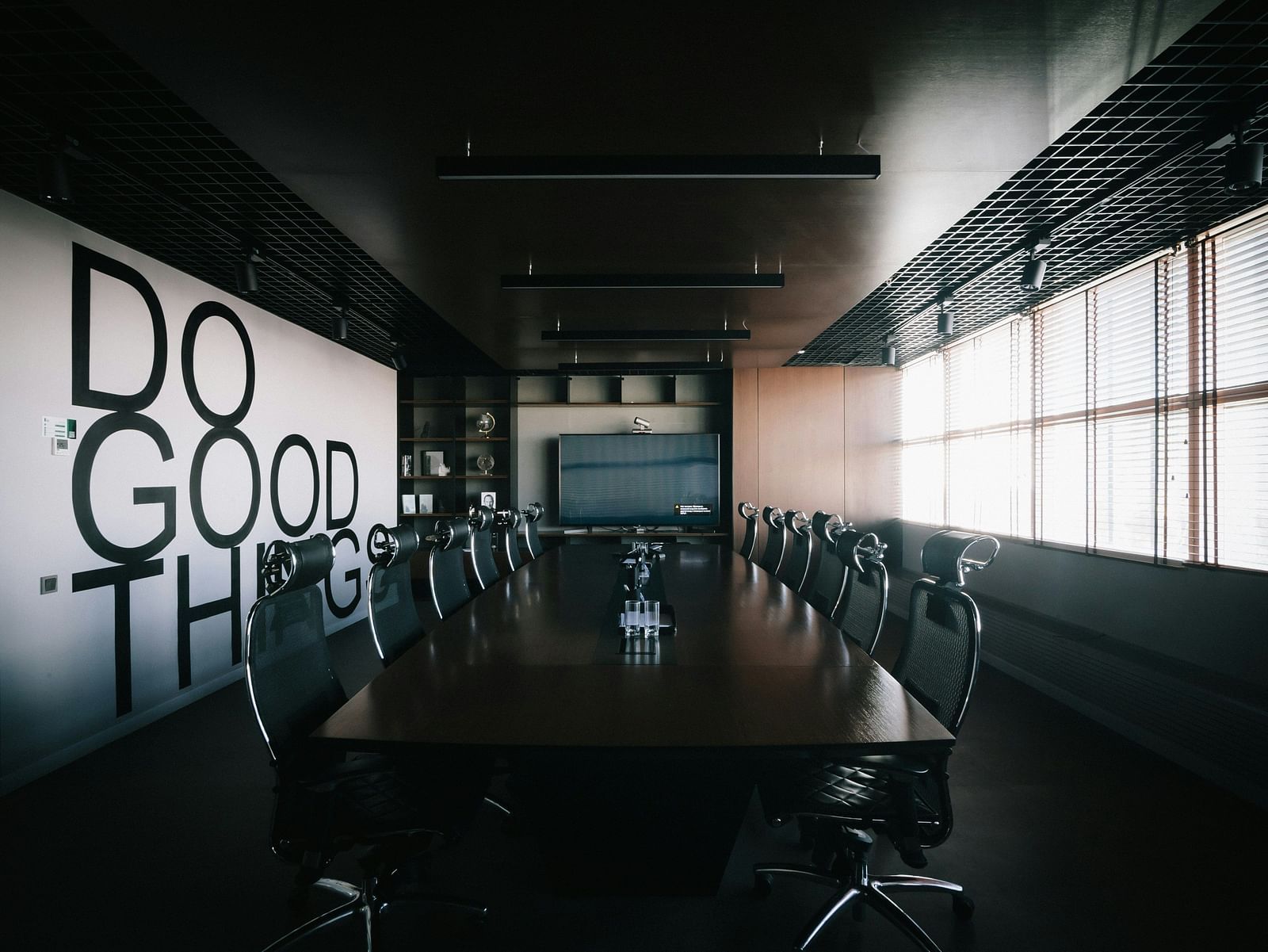 A stylish boardroom with a motivational quote displayed on the wall.