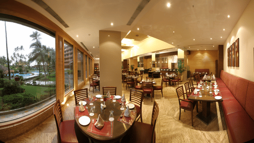 A dining are with tables and chairs at with a scenic view.