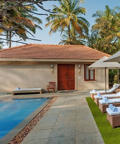 The pathway leading to our cottages by the pool seen during a sunny day - Shreyas Retreat