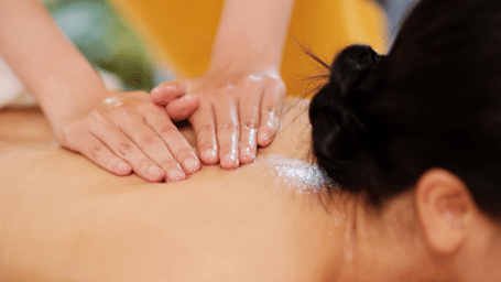 A person getting back massage from a technician.