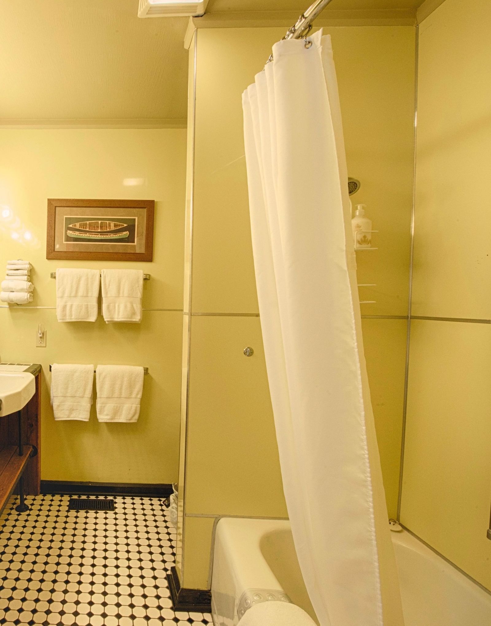 a wide angle shot of a bathroom featuring a bathtub and fresh linens hanging besides the wash basin - Historic Tapoco Lodge