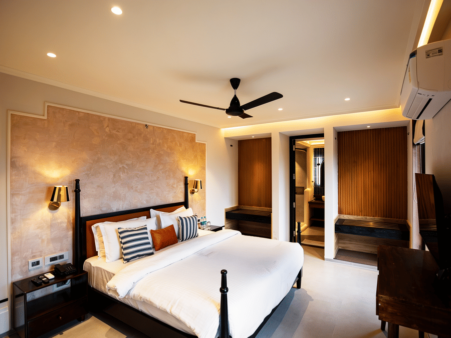 A well-lit bedroom featuring a king size bed, 2 wooden wardrobes, and a black ceiling fan at The Sierra - By The Lake.