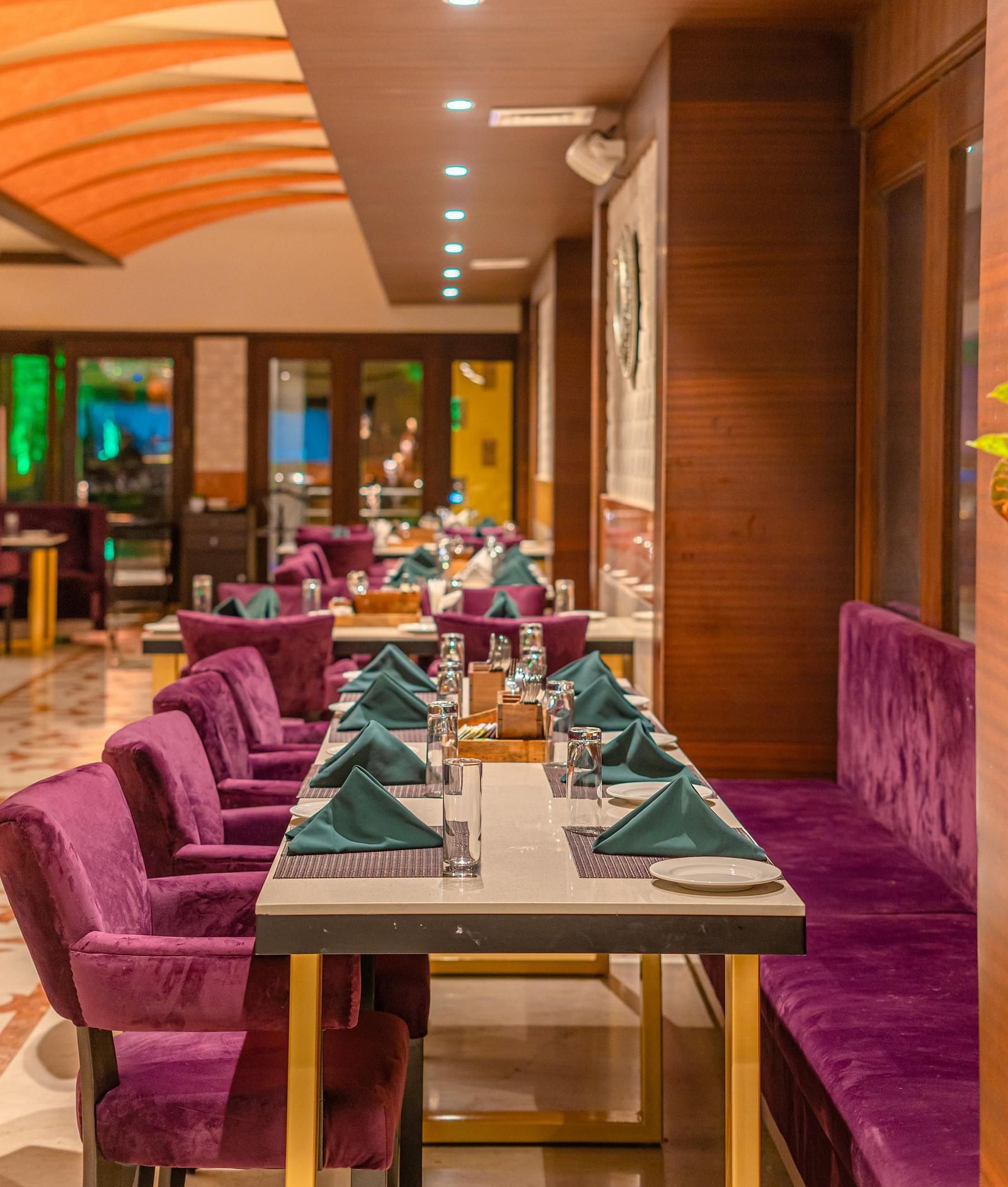 Cushioned chairs and a table set with exquisite culinary offerings for guests at Courtyard Fine Dine, Crescent Spa & Resort, Indore
