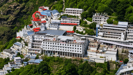 Aerial view of the Vaishno Devi Bhawan complex amidst dense forested hills, highlighting the sacred shrine's impressive mountain setting and scale.