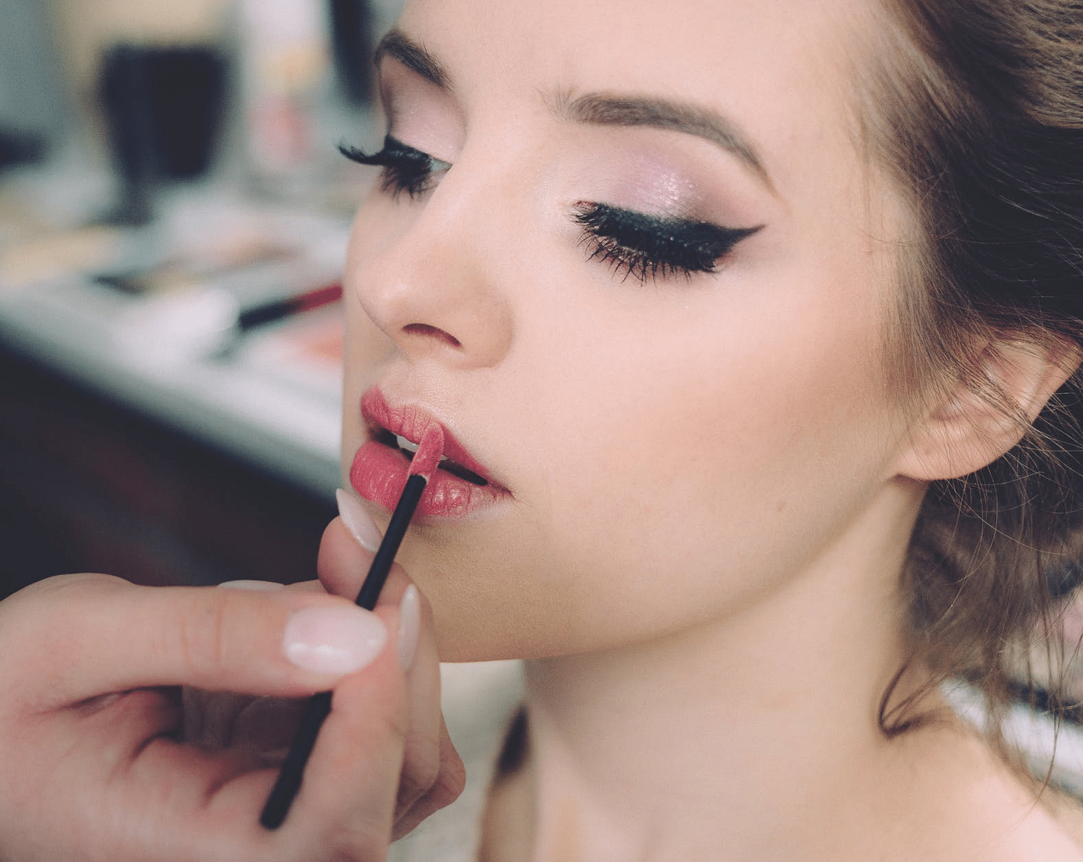 An image of a person getting bride her makeup.